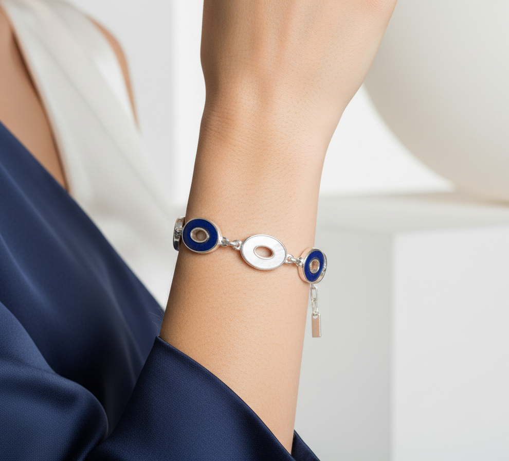 Silver bracelet with blue accents on a wrist against a neutral background
