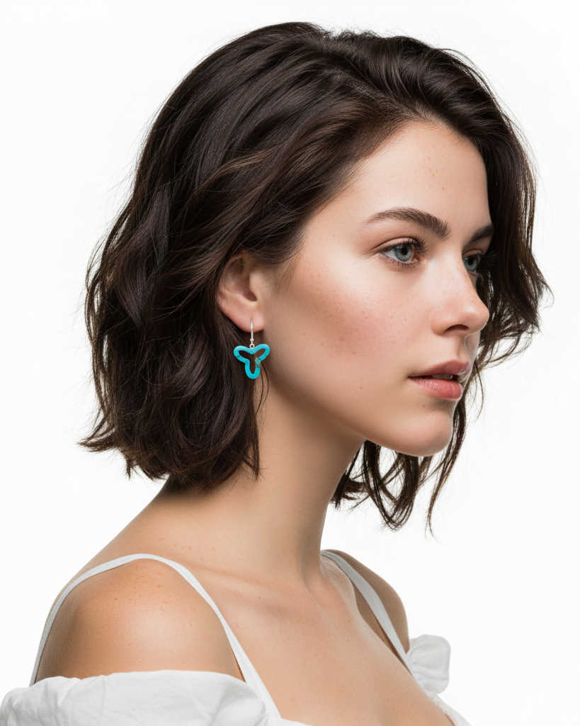 Woman wearing a blue butterfly earring on a white background